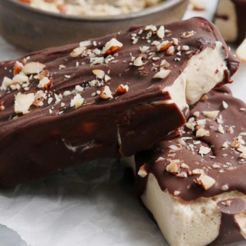 A Bunch of Homemade Eskimo Bars with cashews topping on a white plate